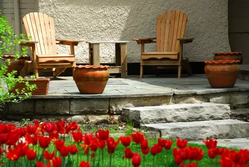 عکس با کیفیت میز و صندلی و باغچه در حیاط
