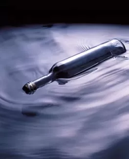 تصویر باکیفیت بطری شیشه ای روی آب